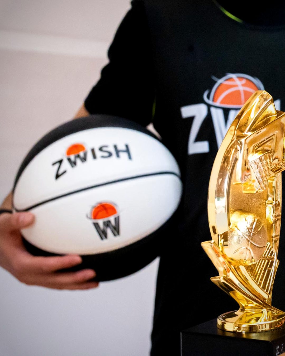 ZWISH basketball held next to a gold trophy